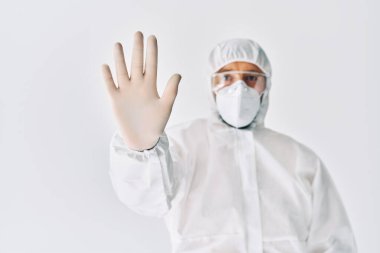 Koruyucu giysili doktor beyaz arka planda dur işareti gösteriyor.