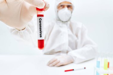 Korunaklı doktor, koronavirüsün kan örneği tüpünü etkilediğini gösteriyor.