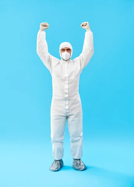 Feliz médico en traje de PPE celebrando su éxito con gesto ganador y manos arriba —  Fotos de Stock