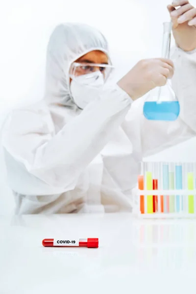 Científico en PPE que trabaja en laboratorio investigando microbiología contra virus — Foto de Stock