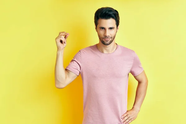 Handsome man snapping fingers on yellow background — Stock Photo, Image