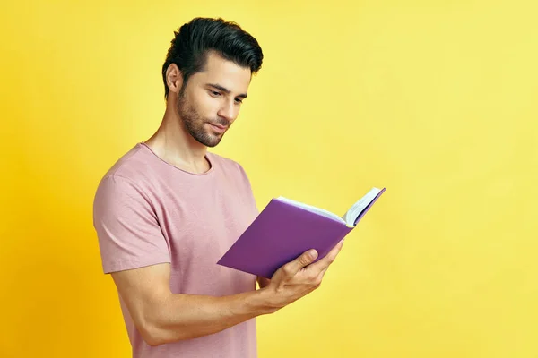 Красивый молодой человек в повседневной одежде читает книгу — стоковое фото