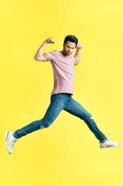 Mutlu heyecanlı adam sarı arka planda zıplıyor