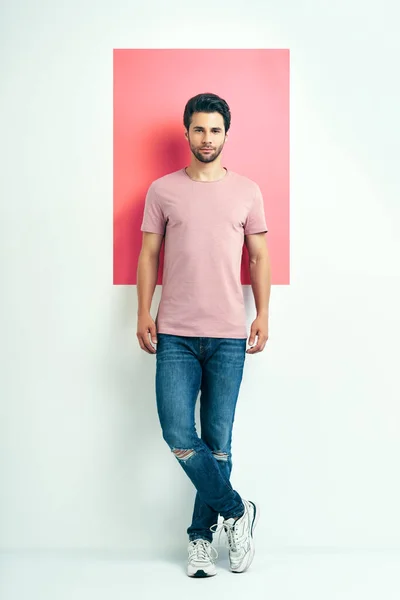 Ganztägiges Porträt eines jungen, gut aussehenden Mannes mit rosa T-Shirt — Stockfoto