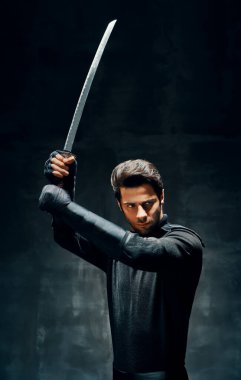 Düşmanı bıçaklamaya hazır bir kılıçla poz veren savaşçı.