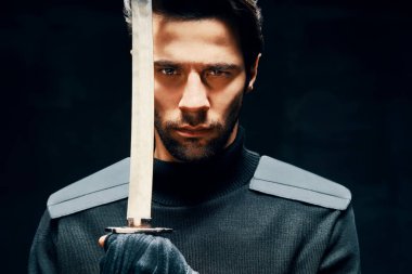 Kılıçla poz veren savaşçı adam.