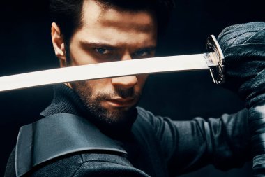 Kılıçla poz veren savaşçı adam.