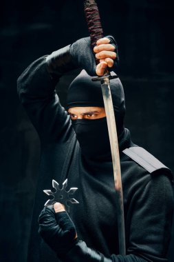 Ninja samuray savaşçı kılıçlı ve shuriken siyah arka planda.