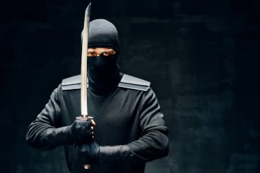 Siyah arka planda kılıçla savaşan ninjalar.