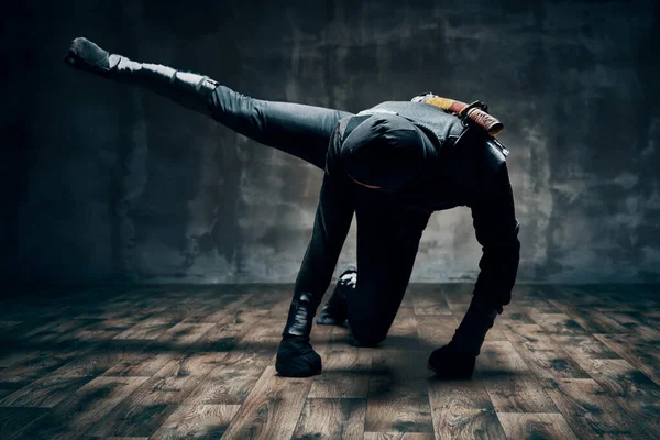 Ninja haciendo movimientos de lucha patadas y puñetazos con la pierna sobre fondo negro — Foto de Stock