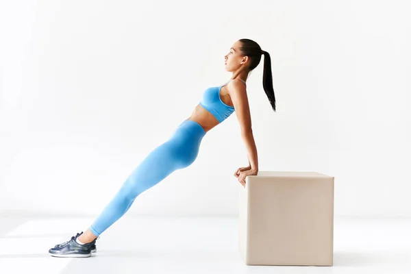 Deportiva mujer haciendo ejercicio de tablón inverso sobre fondo blanco —  Fotos de Stock