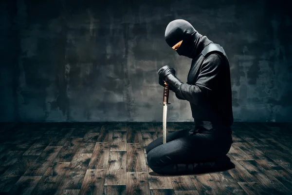 Krieger sitzt auf dem Boden und posiert mit einem Schwert — Stockfoto