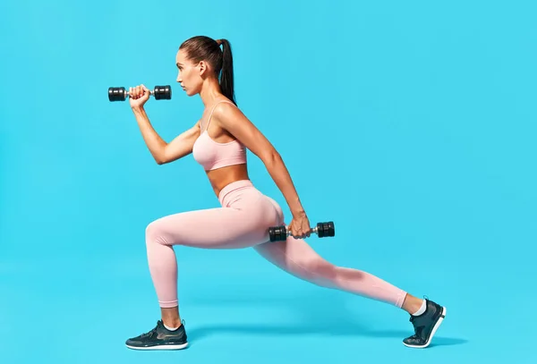 Sportliche Frau macht Ausfallübungen mit Kurzhanteln — Stockfoto