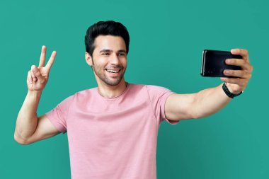 Barış işareti olan yakışıklı adamın portresi selfie çekiyor.