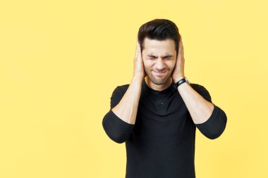 Yakışıklı adam kötü haber duymaktan korkarak elleriyle kulaklarını kapatıyor.