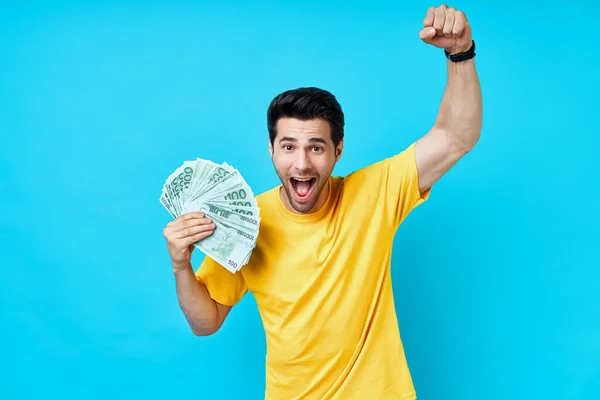 Glad upphetsad man håller stack med pengar på blå bakgrund — Stockfoto