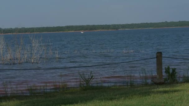 在刮风的日子里 一个有涟漪向岸边流动的湖面的宽幅镜头 — 图库视频影像