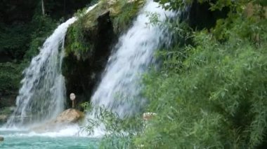Yan görünümü atış ile yeşil çalılar sıçrama ile sallanan bir şelaleler basamaklı suların 