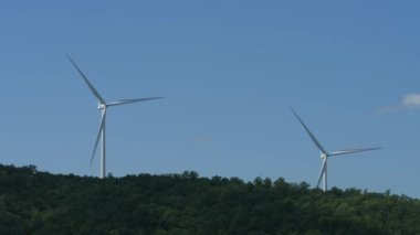 Görünümünde tepe ile bir mesafeden dönen iki rüzgar türbinleri