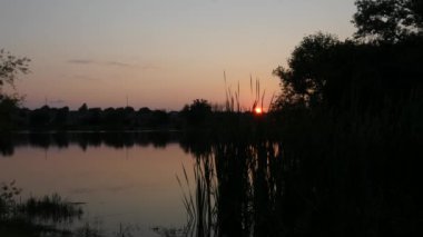 Gölde dramatik günbatımı siluetleri  