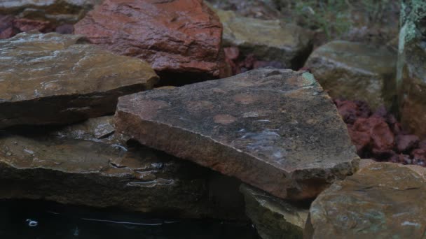 Gouttes de pluie tombant en pierres plates disposées dans le jardin 