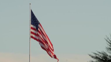 El bir ABD bayrak bir Kutbu'ndan rüzgarlı bir günde sallayarak vurdu.
