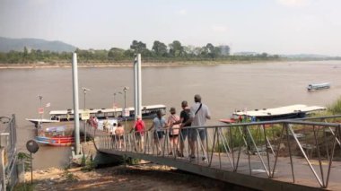 Chiang Rai, Tayland - Mart 2018: İnsanlar Laos 'a geçmek için Mekong Nehri' nden bir tekneye binmek için iskeleye doğru yürüyorlar.