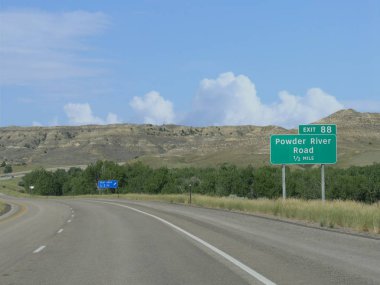 Powder River Road ve dinlenme alanına yön işaretleri ile doğal bir dolambaçlı yolun orta yakın.