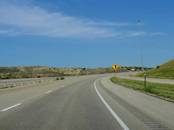 ワイオミング州バッファロー市に向かう途中の道路標識付き舗装曲がりくねった道 — ストック写真