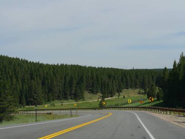 Bighorn County, Wyoming'de yol kenarı işaretleri sürücüleri keskin bir dönüş konusunda uyarıyor.