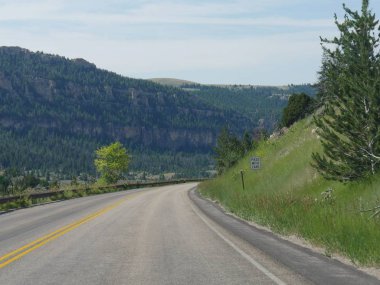 Keskin katlanmış ve wyoming Bighorn Dağları'nda özenle geçmek için bir yol kenarı işareti uyarı sürücüleri ile derin vadiler ve yüksek kayalıklar boyunca yolda döner.