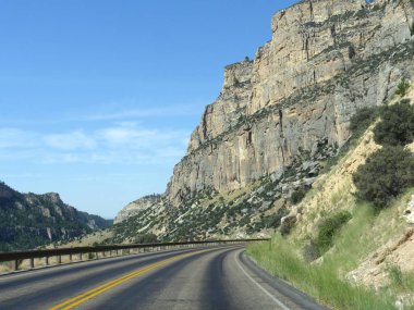Wyoming Bighorn Dağları üzerinden yüksek duvar uçurumlar ve vadiler ile yol boyunca manzara görünümü, gökyüzünde güzel bulutlar ile.