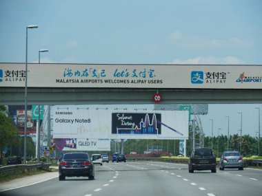 Kuala Lumpur, Malezya--Mart 2018: Araçlar yön işaretleri ve dev Billboard ile bir üst geçit altında gitmek.