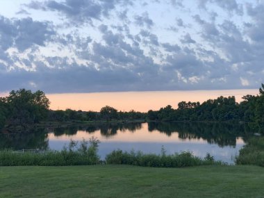 Bir gölün sularına yansıyan gün batımı manzarası