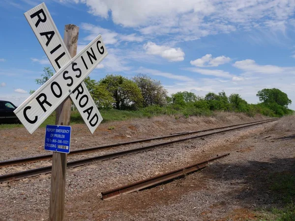 Medium wide shot of a crossing sign at a railroad track