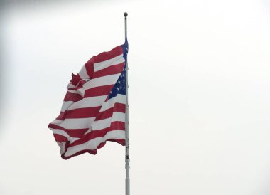 Amerika Birleşik Devletleri bayrağı beyaz arka planda, bir direğin etrafında kürklü