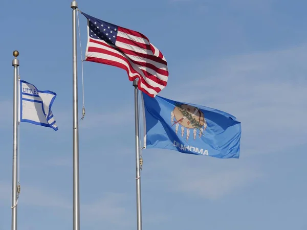 Flags of the United States, Oklahoma State and Little Axe School in Oklahoma  flying from their poles