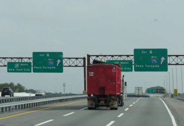 Delaware, Abd- Eylül 2017: New York city ve Penn Turnpike yol tarifi ile eyaletler arası karayolu üzerinde yön işaretleri altından kırmızı bir kamyon geçiyor.