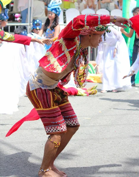 Davao City, Filipinler-Ağustos 2014: Renkli kabile kostümleri bir erkek sokak geçit katılımcısı sokaklarda dans. Kadayawan yaşam ve bol hasat için teşekkür vermek için her yıl Ağustos kutlanır.
