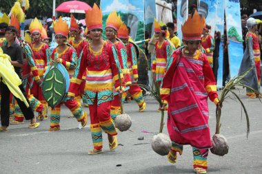 Davao City, Filipinler-Ağustos 2014: Tam kostümlü sokak dansçıları bir sunum sırasında hasat sembolü olarak hindistan cevizi taşırlar. Kadayawan yaşam ve bol hasat için teşekkür vermek için her yıl Ağustos kutlanır.