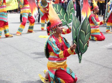 Davao City, Filipinler-Ağustos 2014: Renkli kostümler içinde bir sokak dansçısı bir sunumda boyalı bir yaprak tutar. Kadayawan yaşam ve bol hasat için teşekkür vermek için her yıl Ağustos kutlanır.