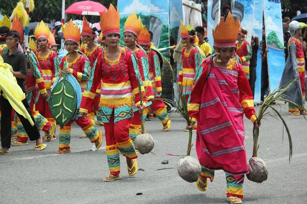 Davao City, Filipinler-Ağustos 2014: Tam kostümlü sokak dansçıları bir sunum sırasında hasat sembolü olarak hindistan cevizi taşırlar. Kadayawan yaşam ve bol hasat için teşekkür vermek için her yıl Ağustos kutlanır.