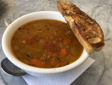 Tost ekmeği ile beyaz bir kapta servis sığır çorbası 