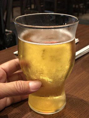 Soğuk bir bardak birayı bir eliyle tutup kapatın.