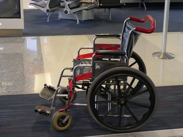 A wheelchair accessible for passengers who needs it an an airport arrival area.