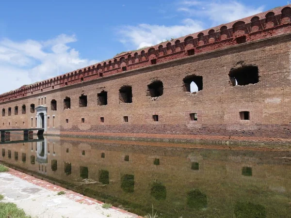 Fort Jefferson, Florida Kuru Tortugas Milli Parkı girişinde orta geniş yan görünüm çekim, hendek sularına yansıyan fort ile. 