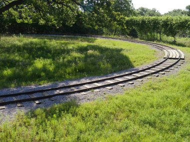 Parkın içinde orta büyüklükte bir tren yolu görüntüsü.