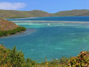 Porto Riko 'nun güzel adası Culebra' daki tepelerin arasında yelkenli yatlarla nefes kesici mavi bir göl manzarası.