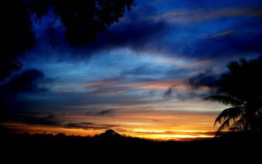 Güzel gün batımı gökyüzü ve uzak tepelerin silueti