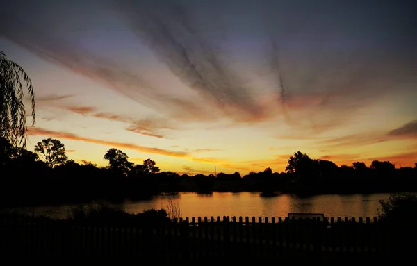 Gyönyörű Naplemente Felhők Felett Tetején Egy Kerítés Jelenik Meg — Stock Fotó